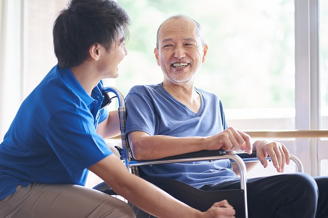 車椅子に乗る高齢者と介護士