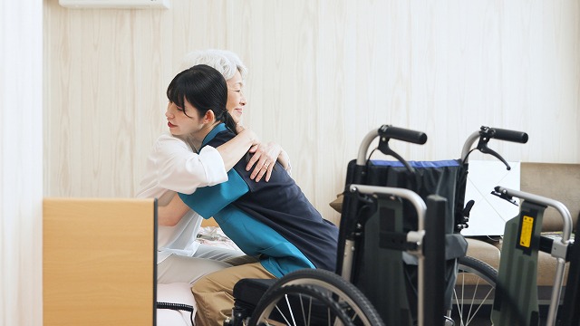 ベッドからの移乗介助を行う介護職員