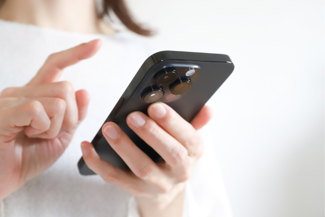 スマートフォンに指で文字を入力している手元